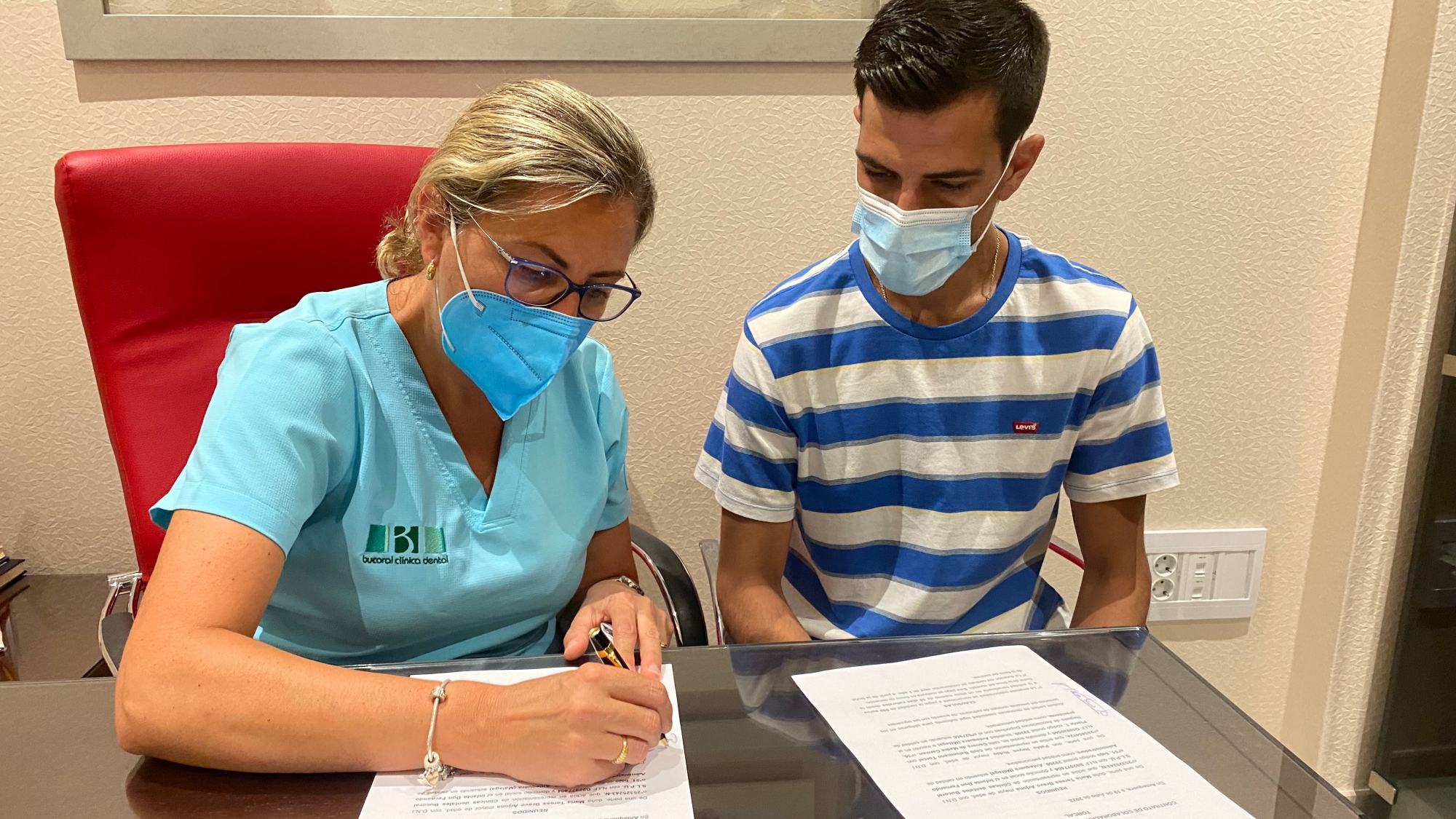María Teresa Bravo, gerente de la Clínica Dental Bucoral, y Pablo Reyes, presidente del Club Balonmano Torcal, firman el acuerdo de patrocinio