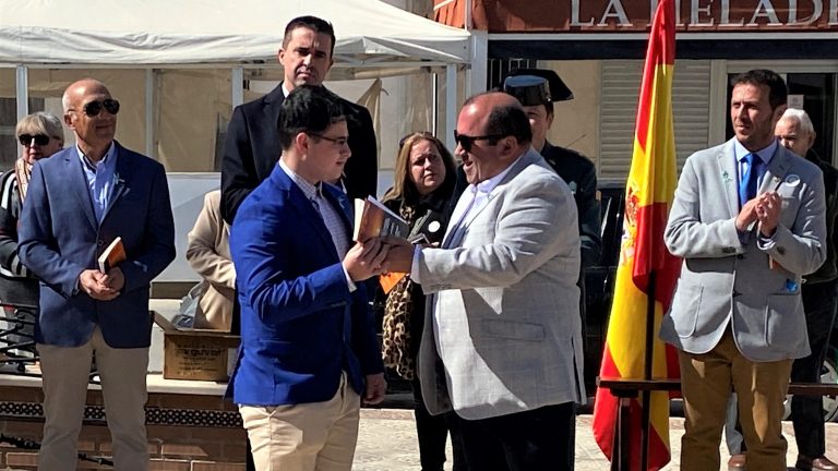 José Querino, entregando a un joven de Sierra de Yeguas una copia de la Constitución Española y el Estatuto Autonómico en la celebración del pasado Día de Andalucía