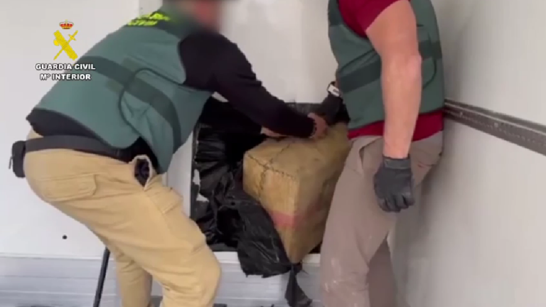 Agentes de la Guardia Civil sacando un fardo de droga guardada en Villanueva del Trabuco de un doble fondo de un vehículo (junio 2024)