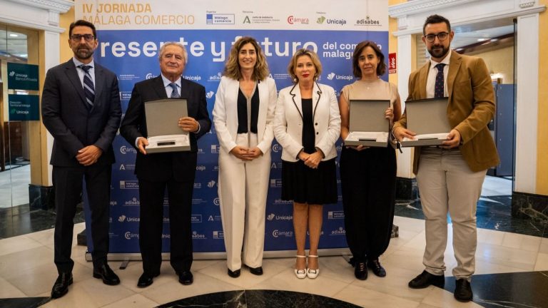 Carmen Sánchez, delegada territorial de Empresa (centro), junto a responsables de Málaga Comercio y entidades reconocidas por la asociación en 2025