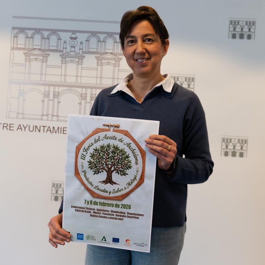 20260113 María Gloria Fernández, concejala de Comercio de Archidona, con el cartel de la III Feria del Aceite, Productos Locales y Sabor a Málaga